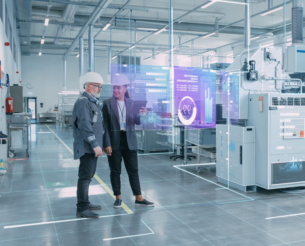 Factory Digitalization: Two Industrial Engineers Use Tablet Computer, Visualize the Wall of Big Data Statistics, Optimization of High-Tech Electronics Facility. Industry 4.0 Machinery Production