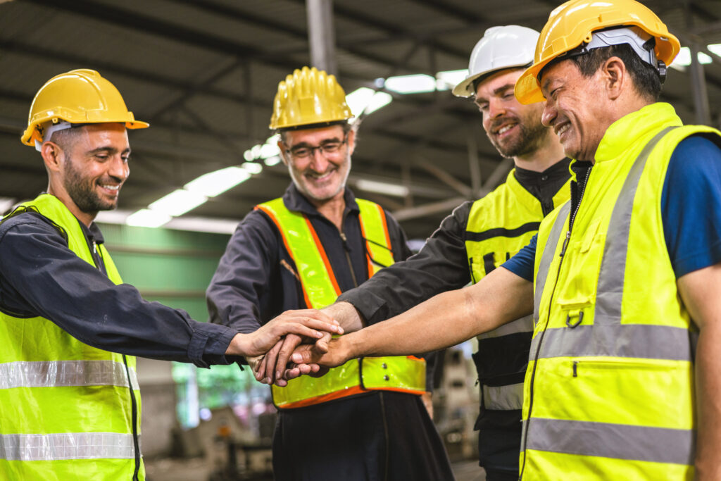 group of construction workers are high fiving each other