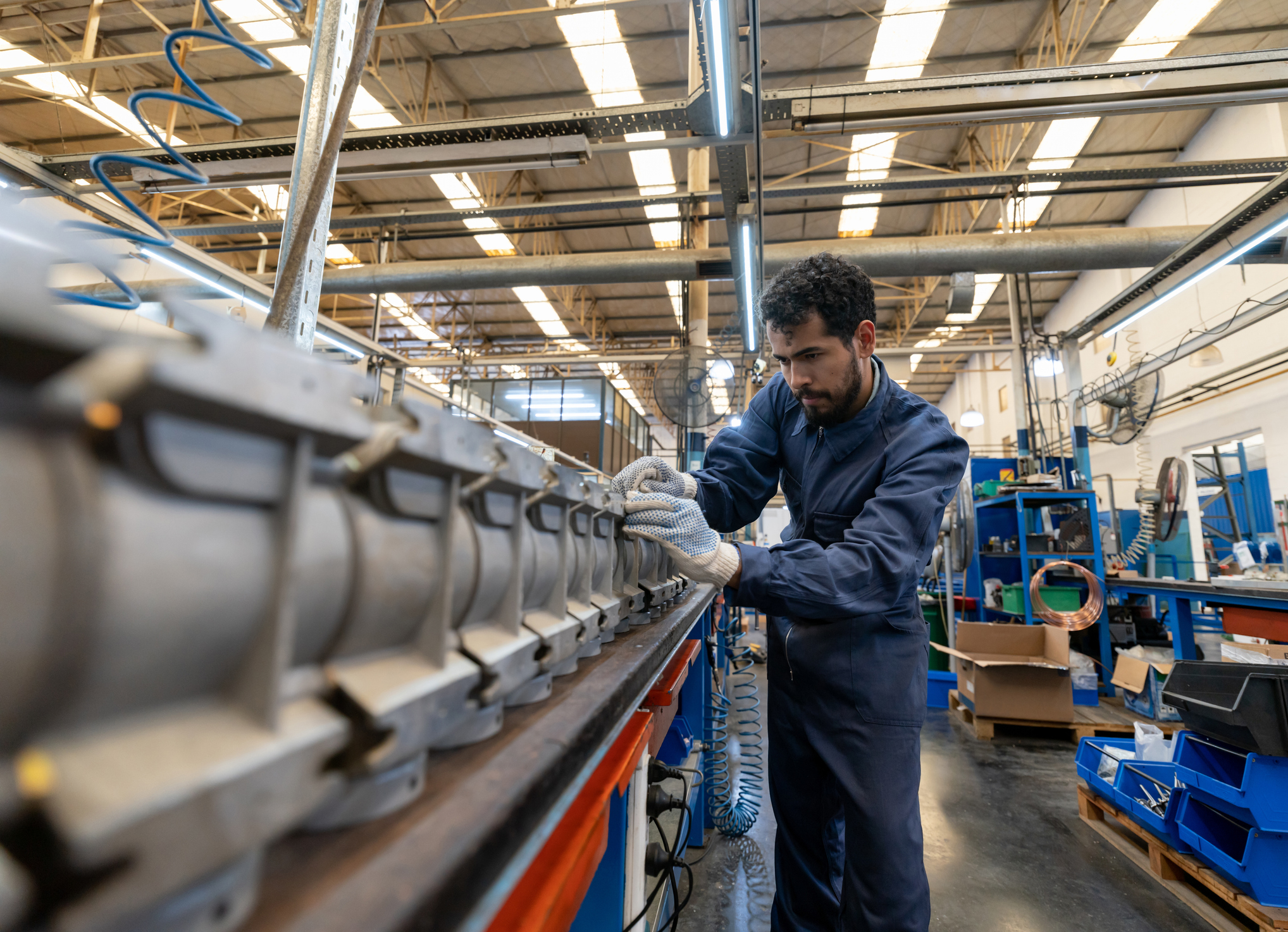 Latin american focused young man working at a manufacturing water pump factory